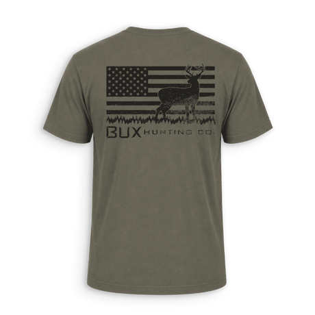 An olive green short-sleeve t-shirt shown from the back, featuring a distressed black graphic of a deer over an American flag with the text 'BUX HUNTING CO.' printed below.