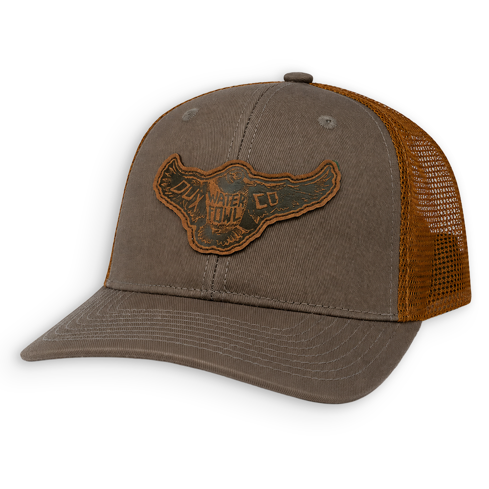 A brown trucker hat with a leather mallard patch on the front.