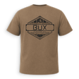 Back of tan crewneck t-shirt with black trim on the collar and sleeve cuffs, featuring a small black line-art deer logo on the left chest, displayed against a solid green background.