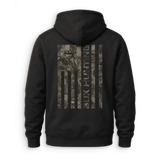 A black pullover hoodie shown from the back, featuring a large vertical American flag graphic on the back in a camouflage pattern with a deer head silhouette and the text 'BUX HUNTING'.