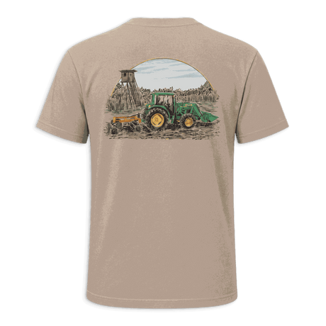 A beige short-sleeve t-shirt with black trim on the collar and sleeve cuffs, featuring a large graphic print on the back of a green tractor and a yellow combine harvester under a semi-circle sky.