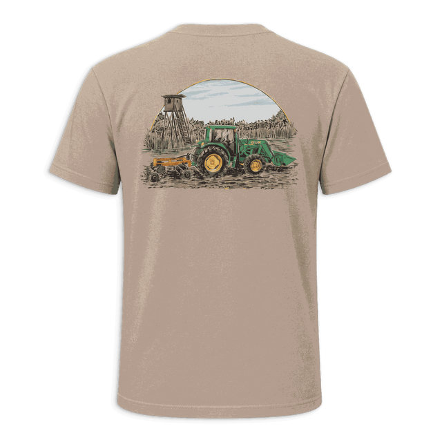 A beige short-sleeve t-shirt with black trim on the collar and sleeve cuffs, featuring a large graphic print on the back of a green tractor and a yellow combine harvester under a semi-circle sky.