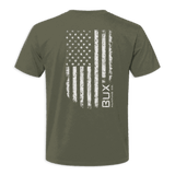 An olive green short-sleeve t-shirt shown from the back, featuring a distressed white American flag graphic with the vertical text 'BUX manufacturing CO.' printed on the right side of the flag.