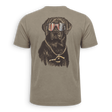 A short-sleeve crewneck t-shirt in a muted taupe-brown color, featuring a large graphic print of a black dog wearing sunglasses with an American flag pattern and a gold chain necklace with a gold 'P' pendant, shown on a clean white background.