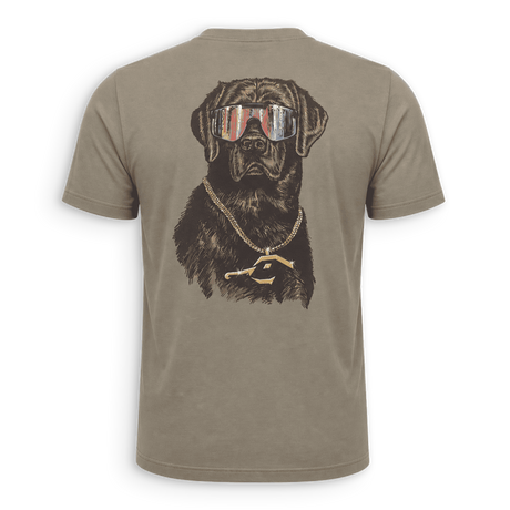 A short-sleeve crewneck t-shirt in a muted taupe-brown color, featuring a large graphic print of a black dog wearing sunglasses with an American flag pattern and a gold chain necklace with a gold 'P' pendant, shown on a clean white background.