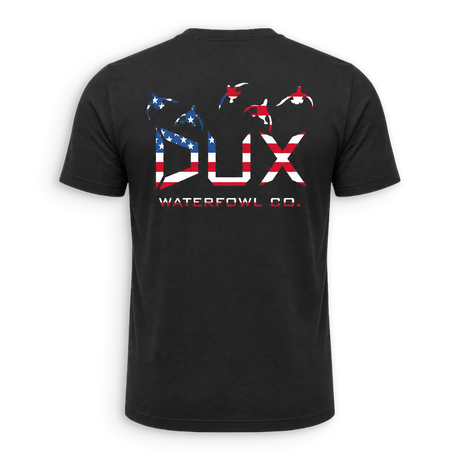 A black short-sleeve t-shirt shown from the back, featuring a large graphic print of the letters 'DUX' filled with an American flag pattern, with three waterfowl silhouettes above and 'WATERFOWL CO.' printed below.