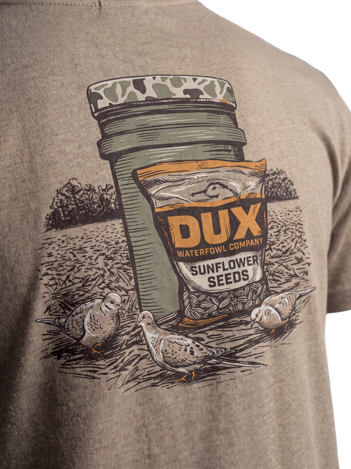 Close-up of a heather taupe t-shirt featuring a graphic print of a Dux Waterfowl Company sunflower seed jar and bag with three doves on a field background.