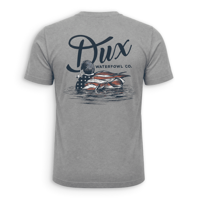 A heather gray short-sleeve t-shirt shown from the back, featuring a large graphic print of a duck with an American flag pattern and the text 'Dux WATERFOWL CO.' above it.
