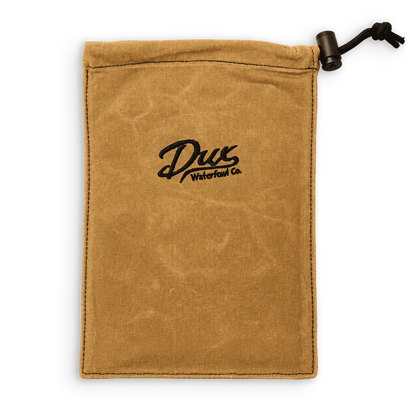 A tan canvas drawstring pouch with a black embroidered logo reading 'Dux Waterfowl Co.' in the center, shown on a plain white background.