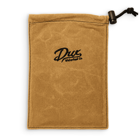 A tan canvas drawstring pouch with a black embroidered logo reading 'Dux Waterfowl Co.' in the center, shown on a plain white background.