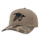 A structured baseball cap in tan with a camouflage-patterned brim and an embroidered flying mallard duck on the front, shown on a plain white background.