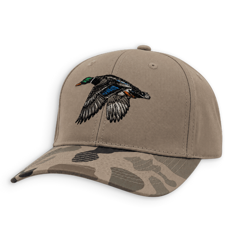 A structured baseball cap in tan with a camouflage-patterned brim and an embroidered flying mallard duck on the front, shown on a plain white background.