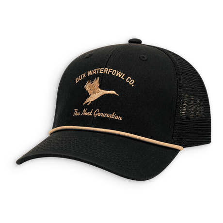 A black trucker hat with a curved brim, black mesh back, and tan embroidered logo and text reading 'DUX WATERFOWL CO.' and 'The Next Generation' on the front panel.
