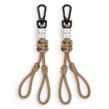 Two tan paracord keychains with black carabiners and white DUX brand labels, displayed side-by-side on a white background.