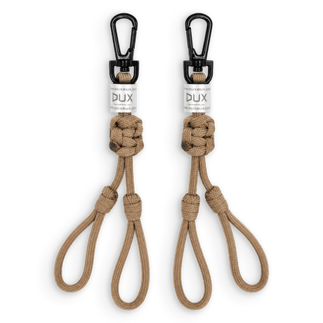 Two tan paracord keychains with black carabiners and white DUX brand labels, displayed side-by-side on a white background.