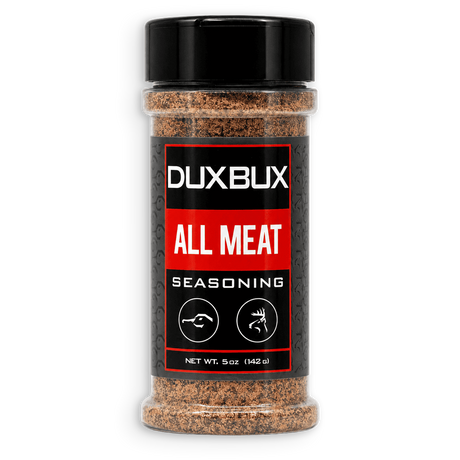 A 5 oz clear plastic bottle of Duxbux All Meat Seasoning with a black cap and a black, red, and white label, shown on a plain white background.