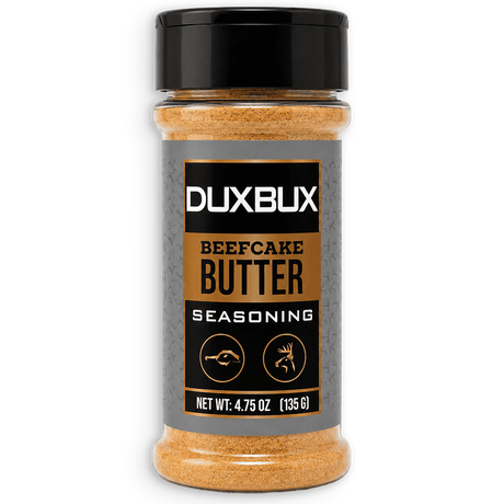A bottle of Duxbux Beefcake Butter Seasoning with a black cap and a gray label featuring gold and black text, set against a plain white background.