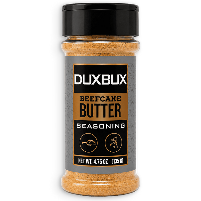 A bottle of Duxbux Beefcake Butter Seasoning with a black cap and a gray label featuring gold and black text, set against a plain white background.