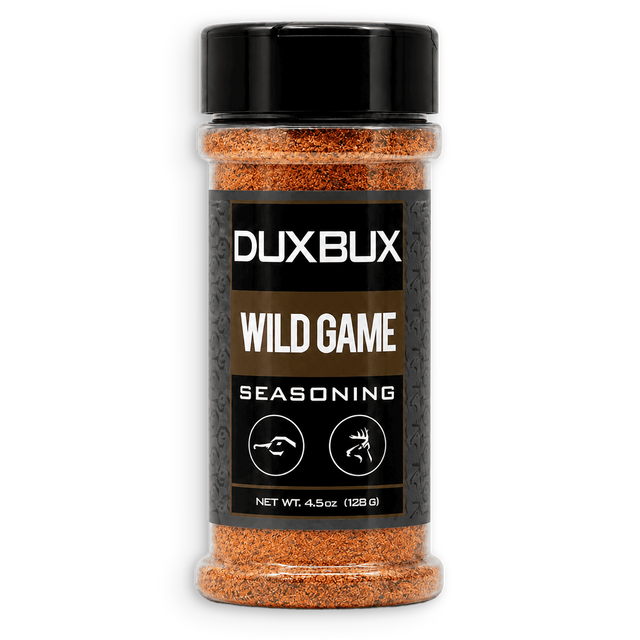 A clear plastic spice jar of DUXBUX Wild Game Seasoning with a black lid and black label, showing orange-brown seasoning inside, on a white background.