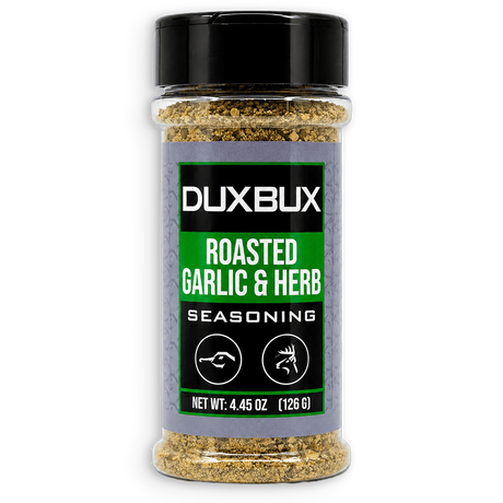 A clear plastic spice jar of Duxbux Roasted Garlic & Herb Seasoning with a black lid and a black and green label, set against a plain white background.