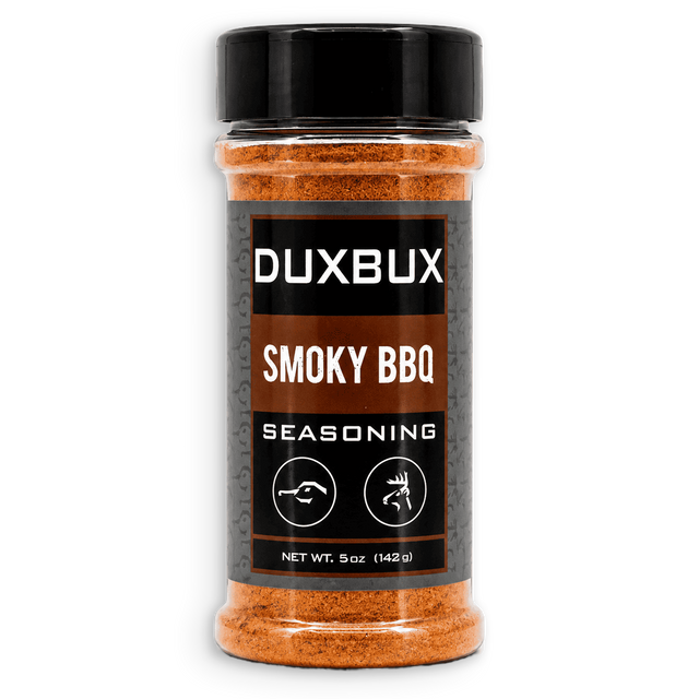 A 5 oz clear plastic bottle of DUXBUX Smoky BBQ Seasoning with a black cap and a black label, showing the orange-brown seasoning inside, on a white background.