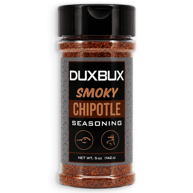 A 5 oz bottle of Duxbux Smoky Chipotle Seasoning, featuring a black cap and a black label with brown and white text, filled with reddish-brown seasoning powder, shown on a white background.