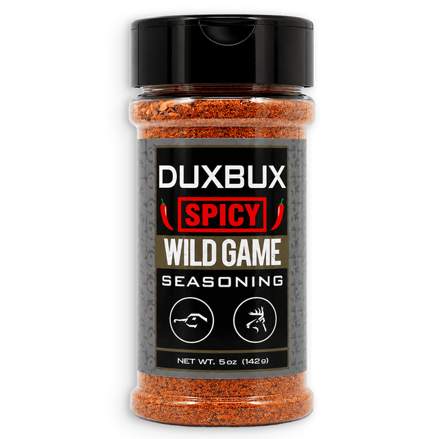 A 5 oz clear plastic spice jar of Duxbux Spicy Wild Game Seasoning with a black cap and a black label, filled with orange-red seasoning blend, on a white background.