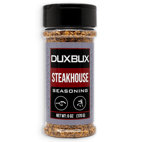 A 6 oz clear plastic bottle of Duxbux Steakhouse Seasoning with a black cap and a gray, red, and black label, shown on a white background.