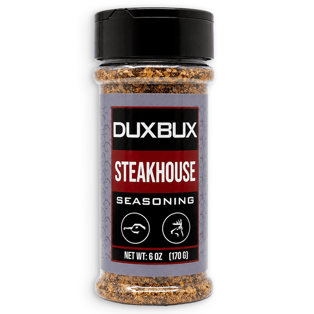 A 6 oz clear plastic bottle of Duxbux Steakhouse Seasoning with a black cap and a gray, red, and black label, shown on a white background.